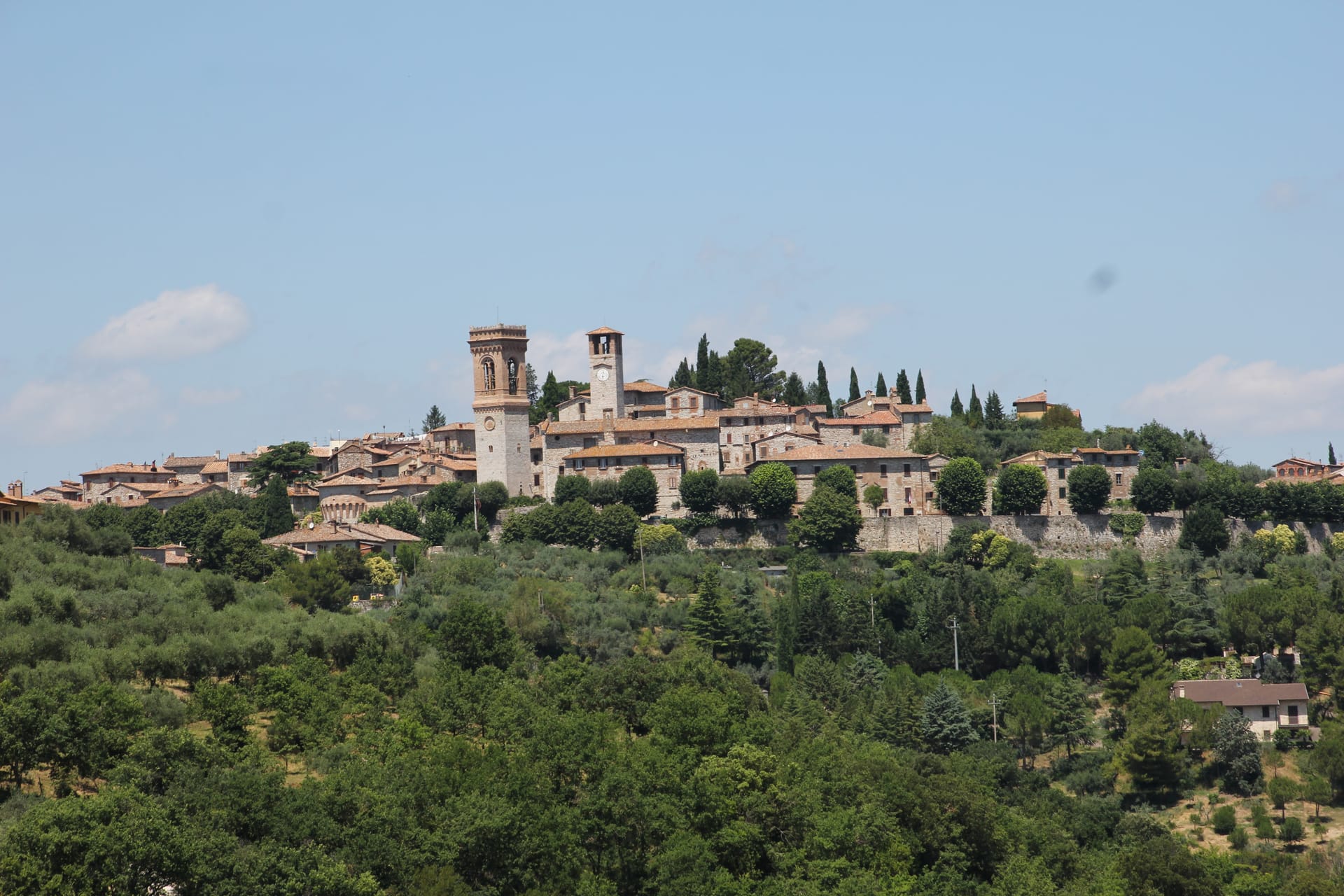Panorama del borgo medievale di Corciano con campanile e torre, visto dalla campagna umbra